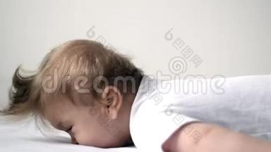 一岁的残疾儿童躺在床上试图抬起头